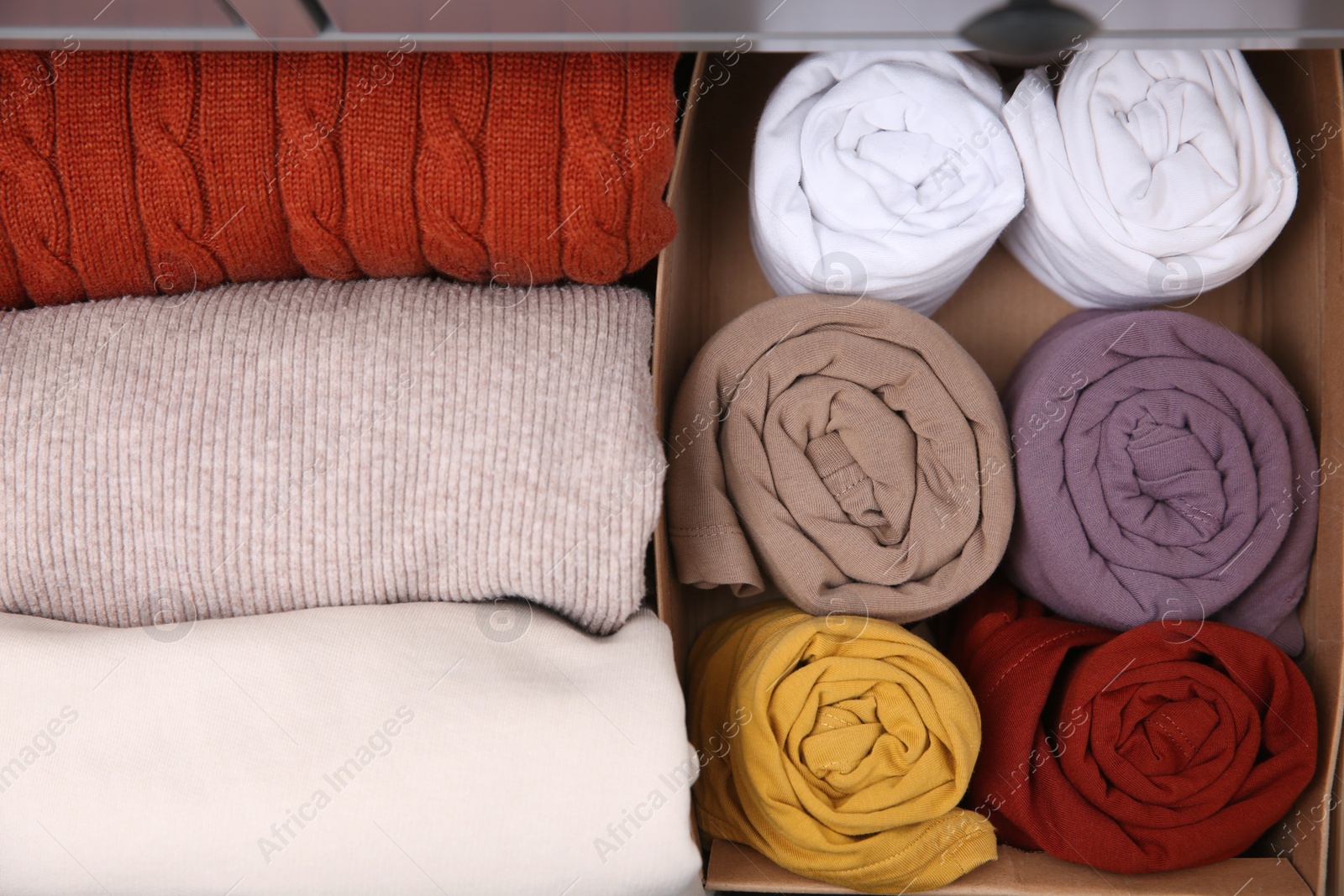 Photo of Different folded clothes as background, top view. Vertical storage