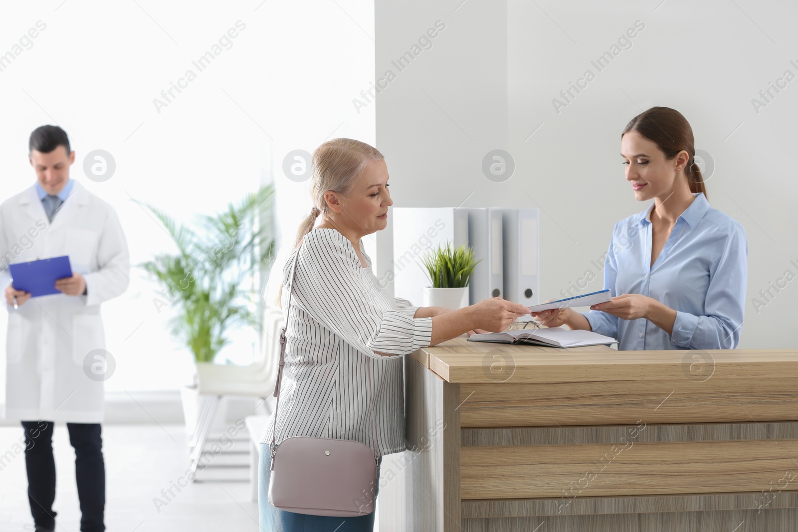 Photo of Patient taking her medical record before doctor's appointment in hospital