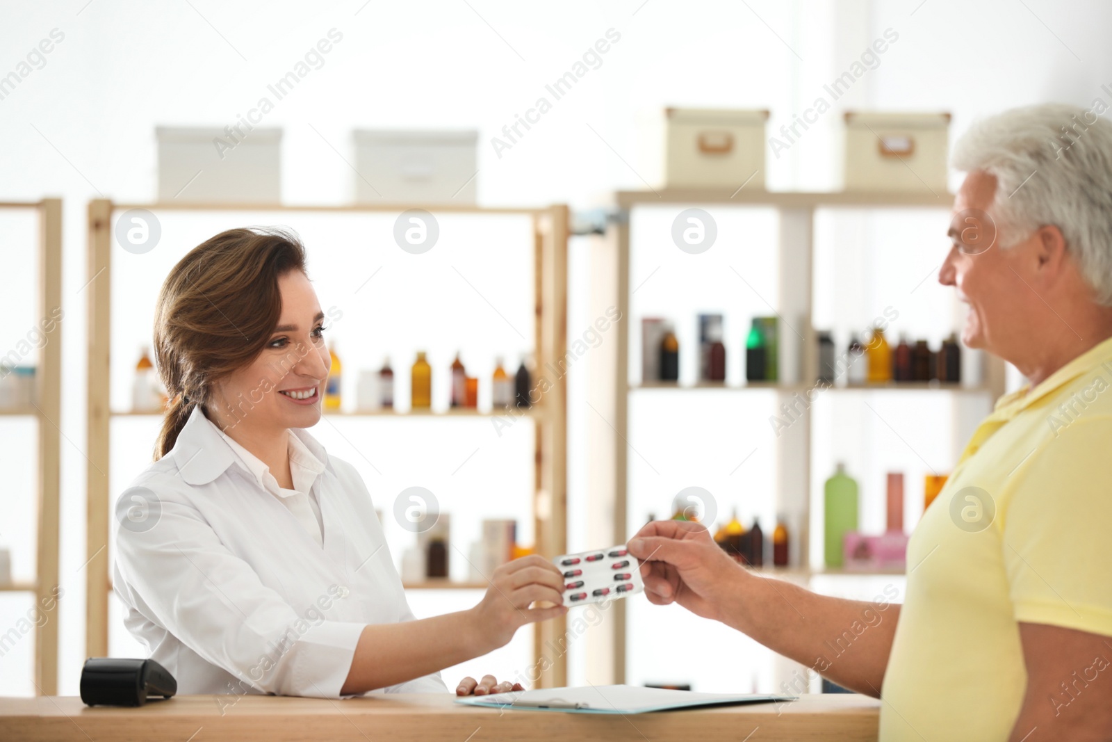 Photo of Pharmacist giving medicine to customer in drugstore