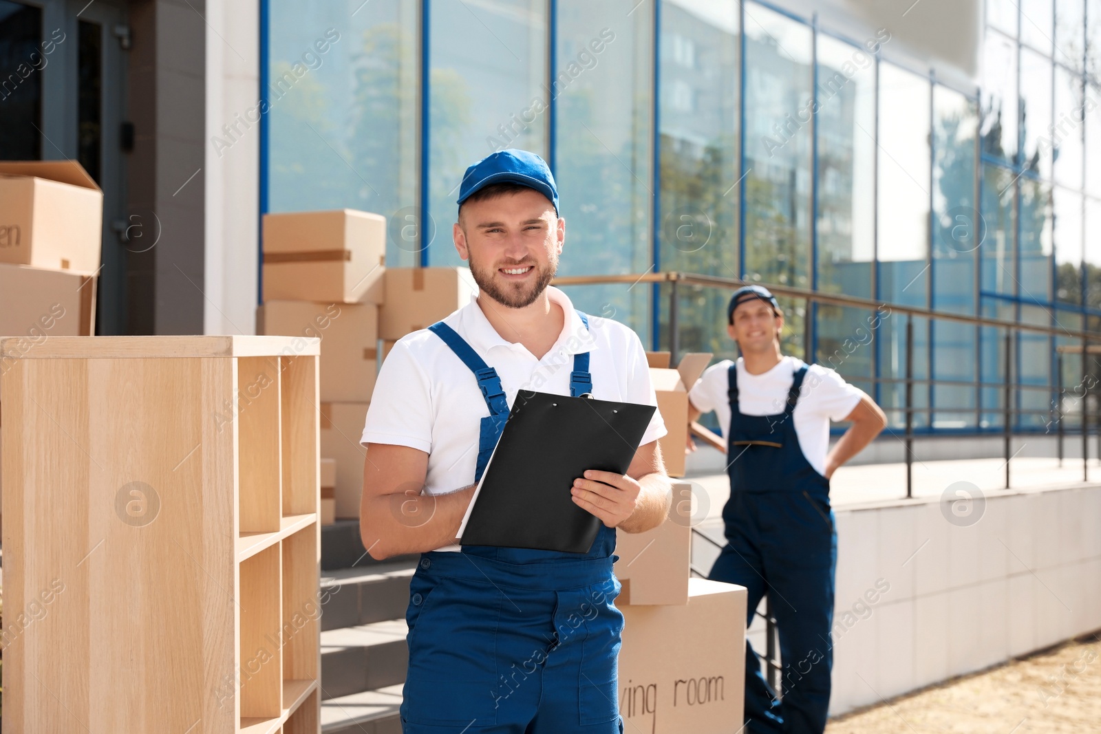 Photo of Male mover with clipboard outdoors on sunny day