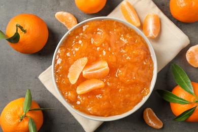 Flat lay composition with tasty tangerine jam on grey table