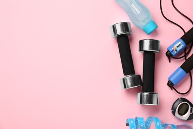 Photo of Flat lay composition with dumbbells on pink background, space for text