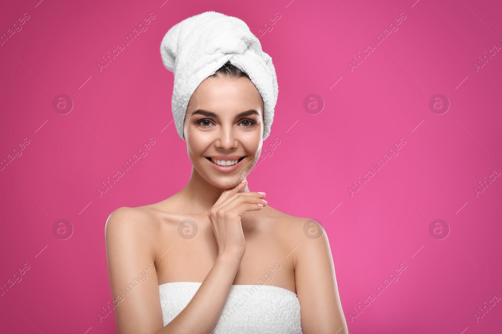 Photo of Happy young woman with towel on head against pink background, space for text. Washing hair