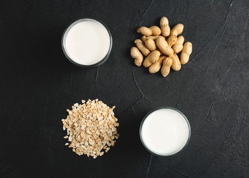 Photo of Glasses with peanut and oat milk on grey background