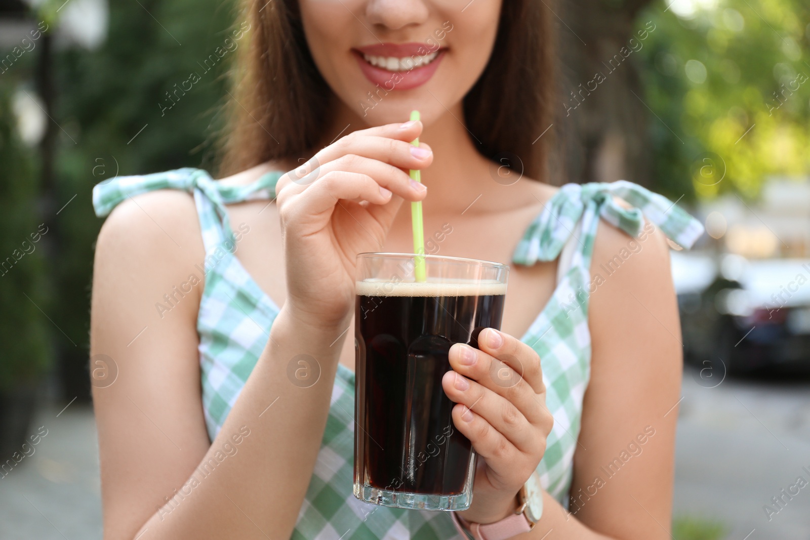 Photo of Young woman with cold kvass outdoors, closeup. Traditional Russian summer drink