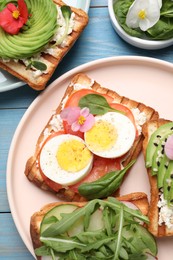 Different delicious sandwiches on light blue wooden table, flat lay