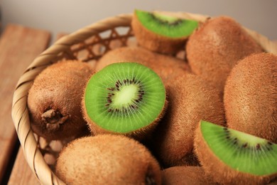 Photo of Wicker basket with whole and cut kiwis, closeup