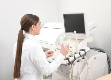 Photo of Professional sonographer using modern ultrasound machine in clinic