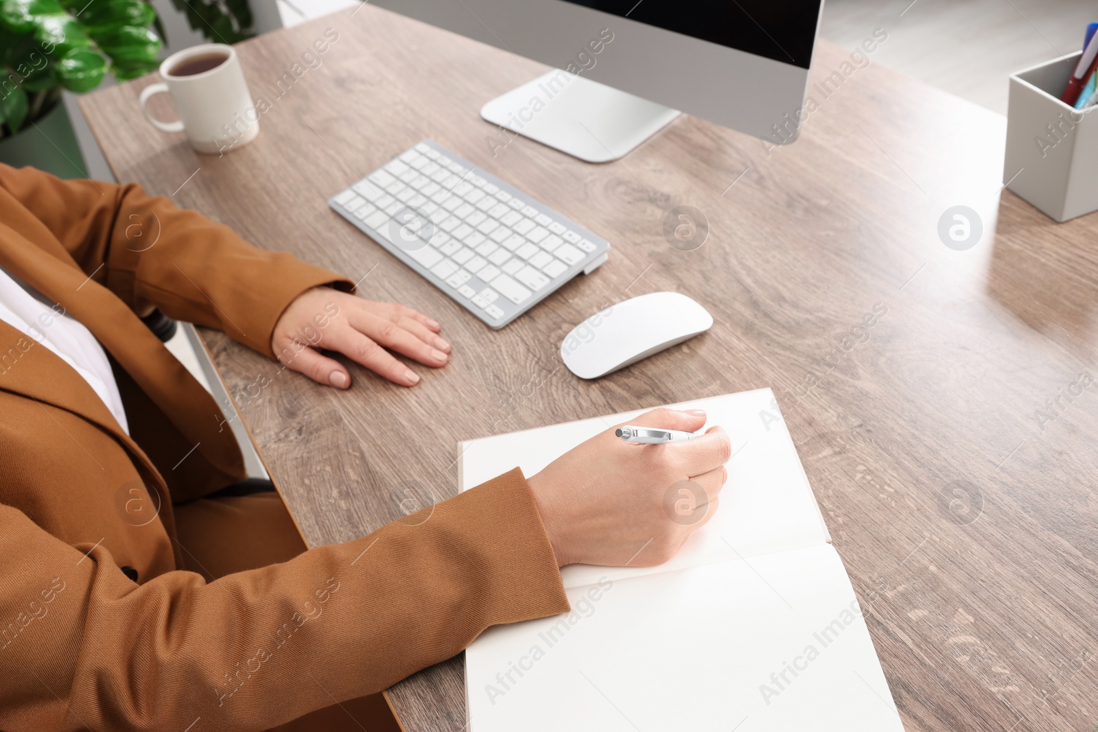 Photo of Lady boss working near computer at desk indoors, closeup. Successful businesswoman