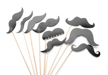 Photo of Fake paper mustaches with party props isolated on white, top view