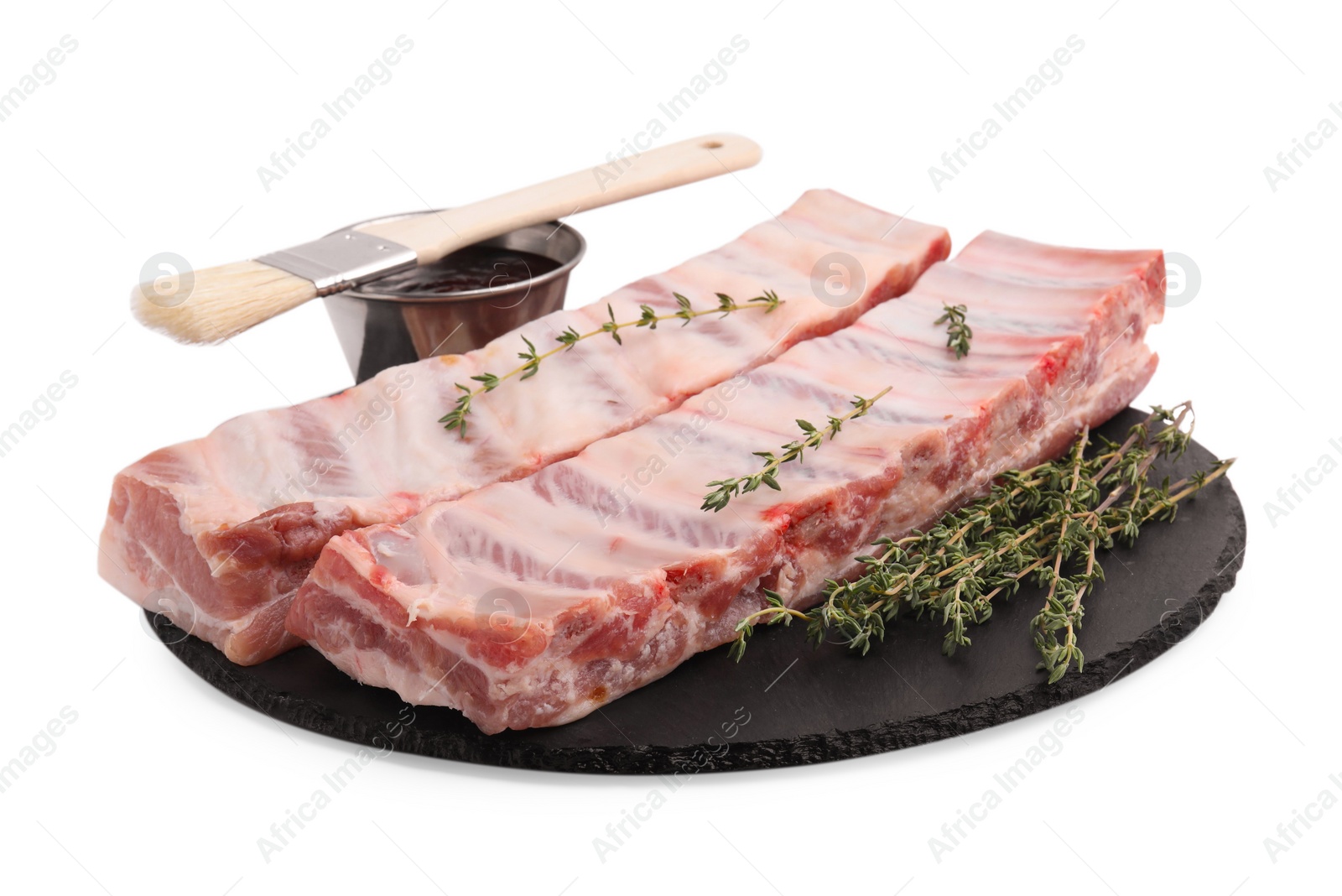 Photo of Raw pork ribs, thyme and sauce isolated on white