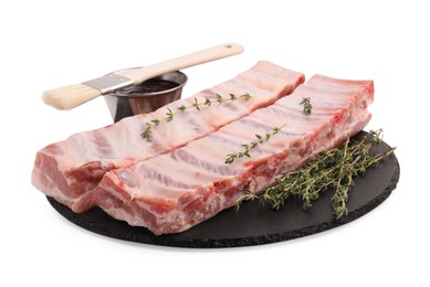 Photo of Raw pork ribs, thyme and sauce isolated on white