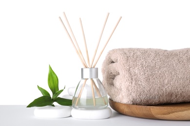 Photo of Composition with towel, air freshener and spa stones isolated on white