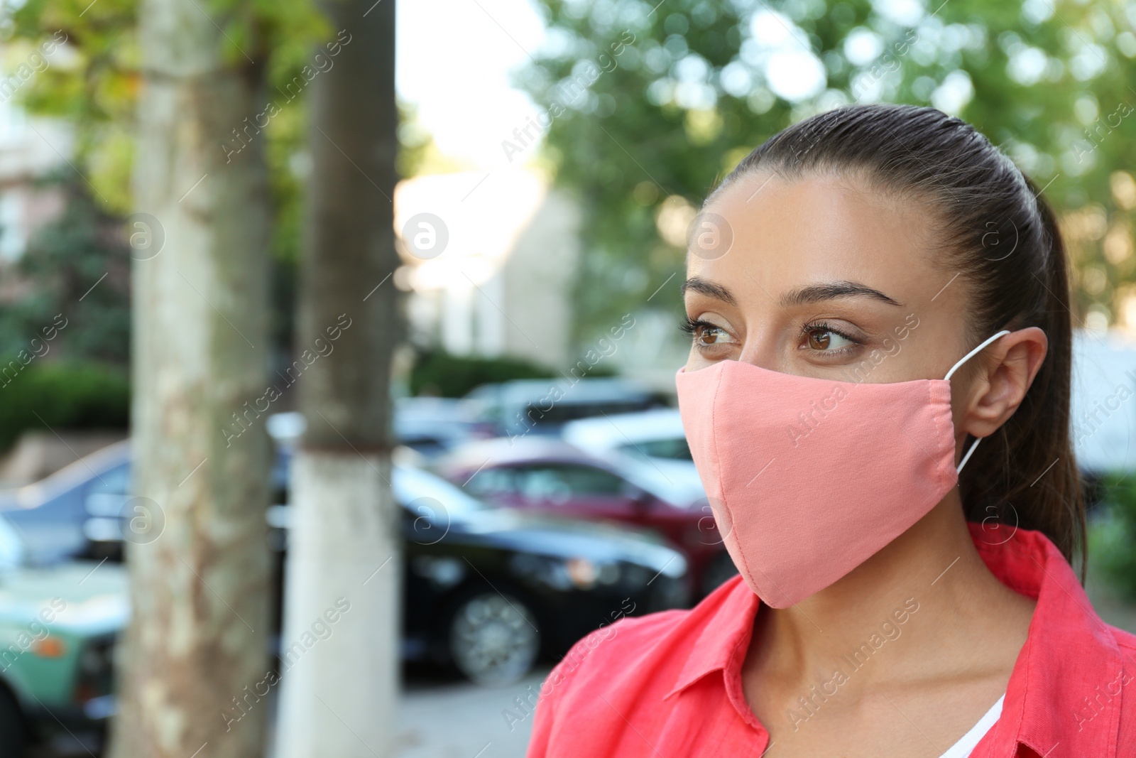 Photo of Woman wearing handmade cloth mask outdoors, space for text. Personal protective equipment during COVID-19 pandemic