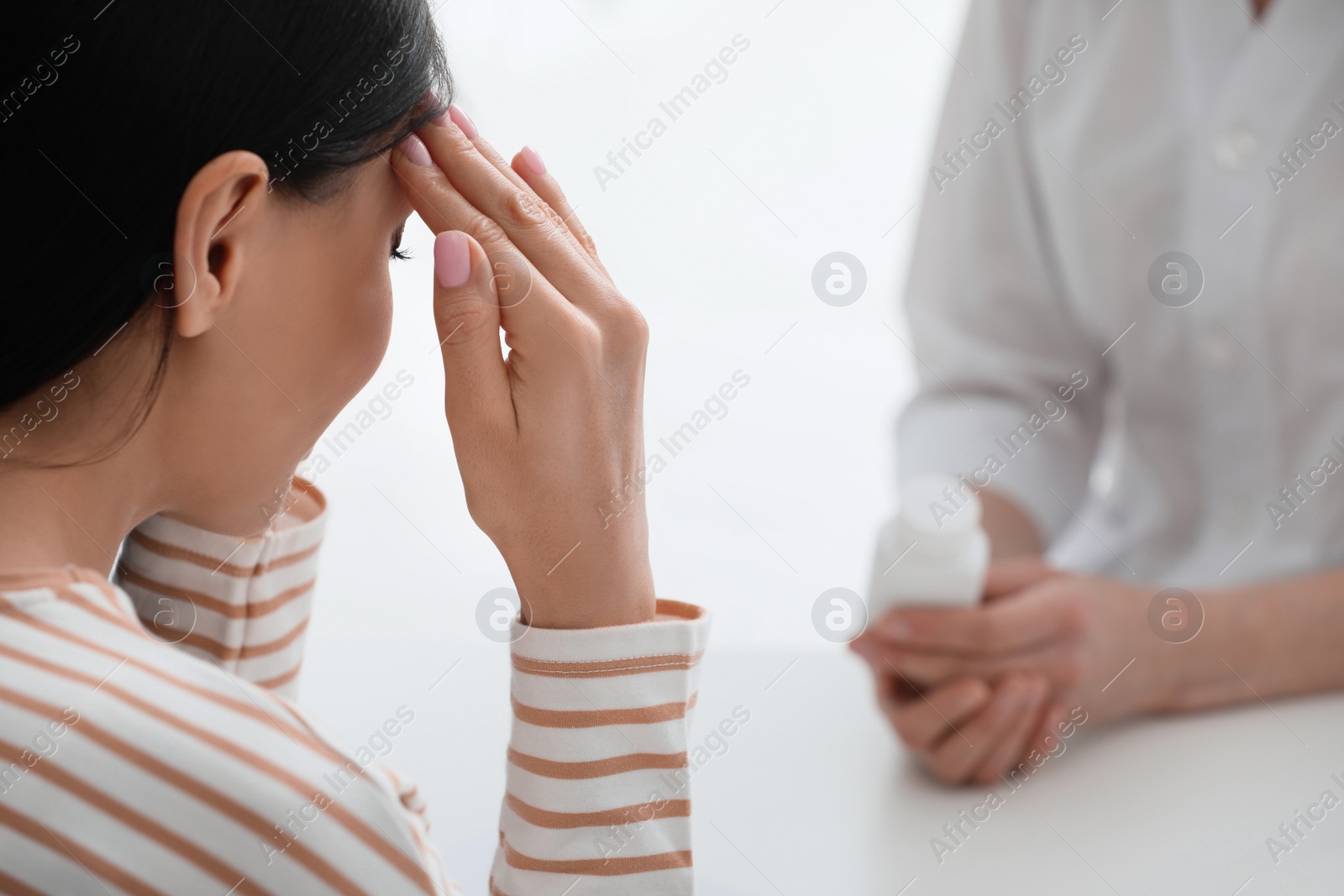 Photo of Young woman suffering from migraine in hospital, closeup