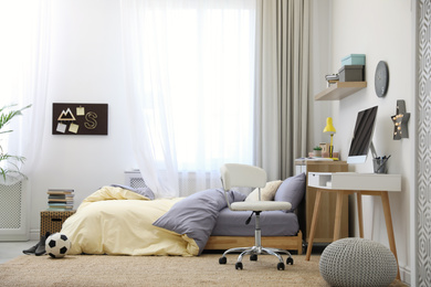 Photo of Stylish teenager's room interior with comfortable bed and workplace