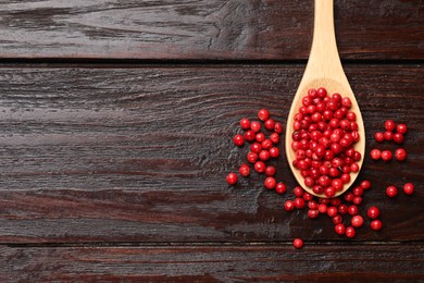 Photo of Aromatic spice. Red pepper in spoon on wooden table, top view. Space for text