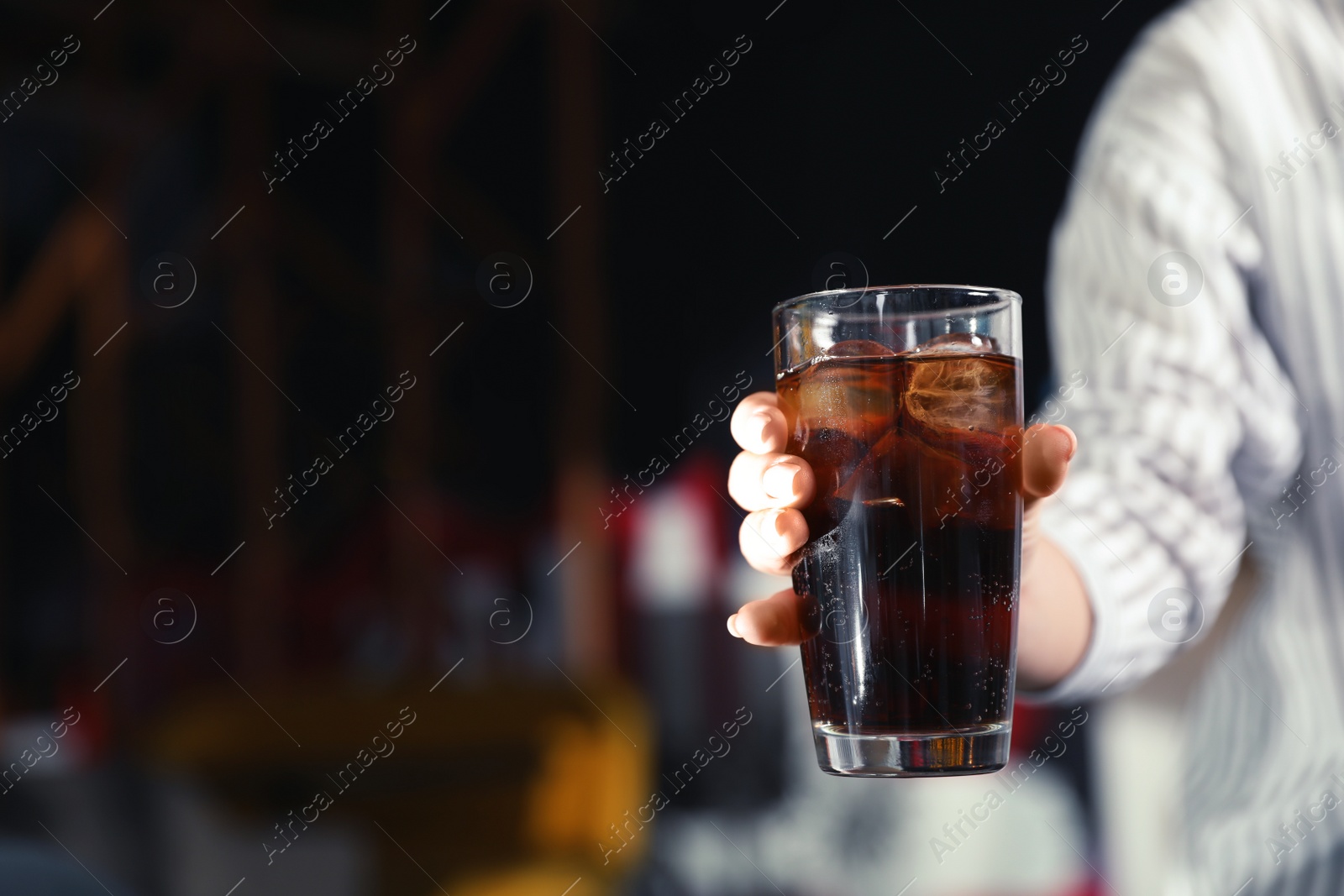 Photo of Woman with glass of refreshing cola indoors, closeup. Space for text