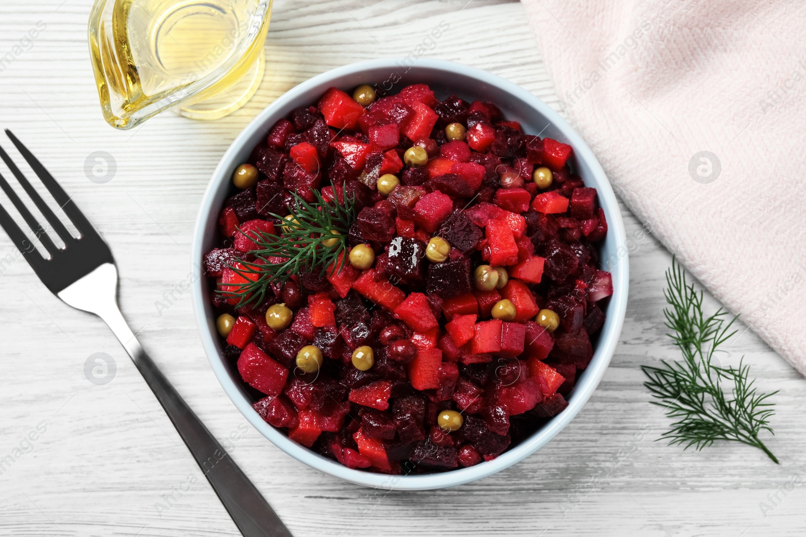 Photo of Traditional Russian salad vinaigrette served on white wooden table, flat lay