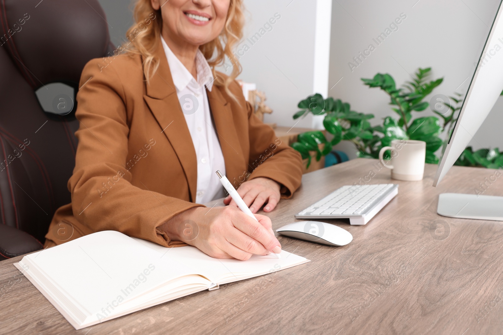 Photo of Lady boss working near computer at desk in office, closeup. Successful businesswoman
