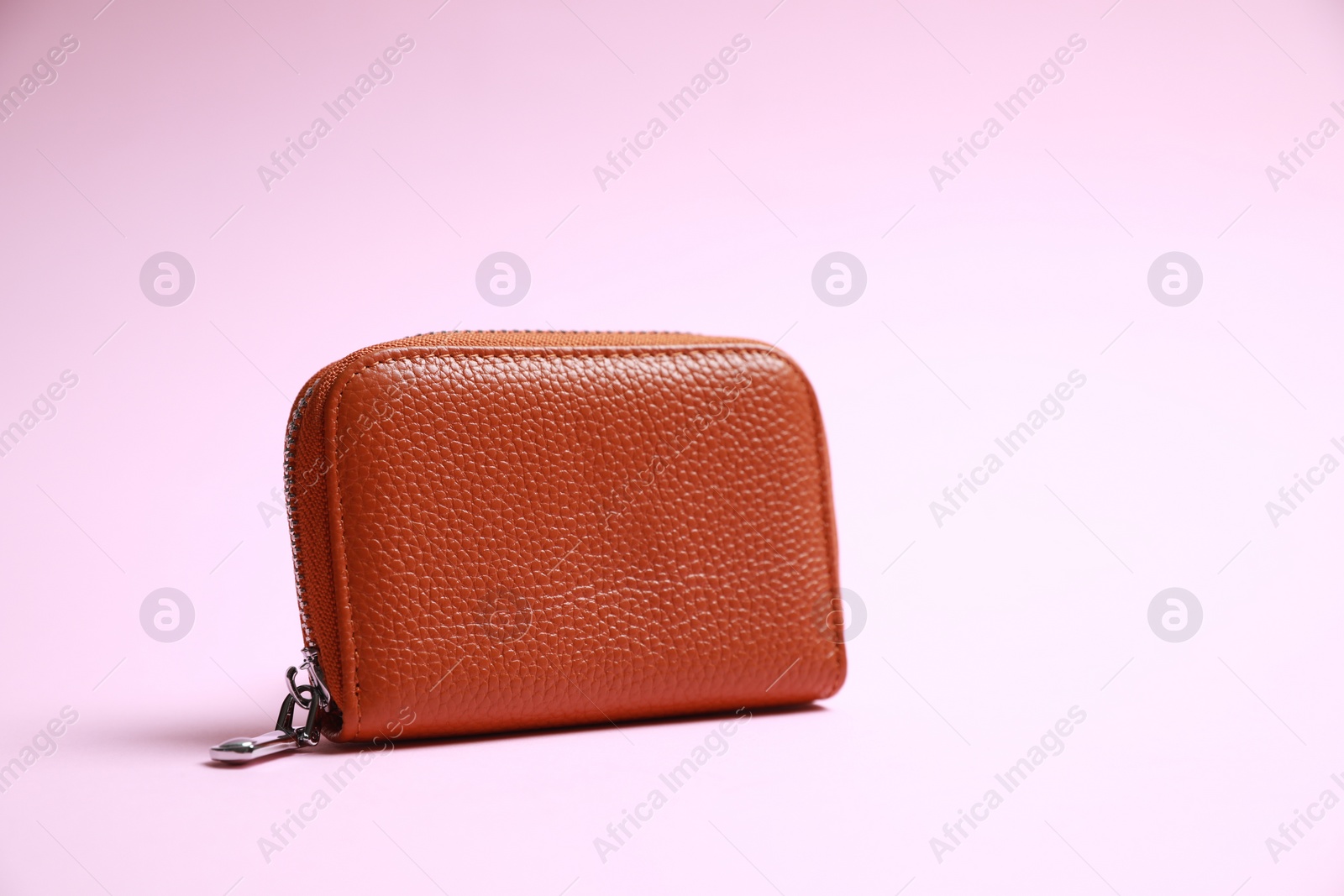 Photo of Stylish brown leather purse on pink background, space for text