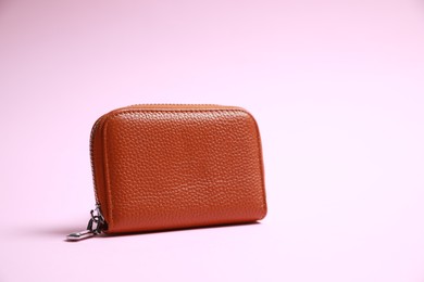Photo of Stylish brown leather purse on pink background, space for text