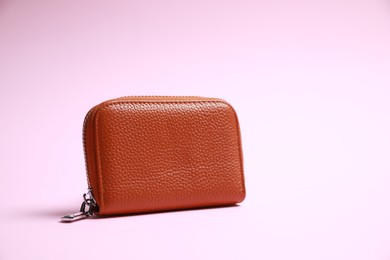 Stylish brown leather purse on pink background, space for text