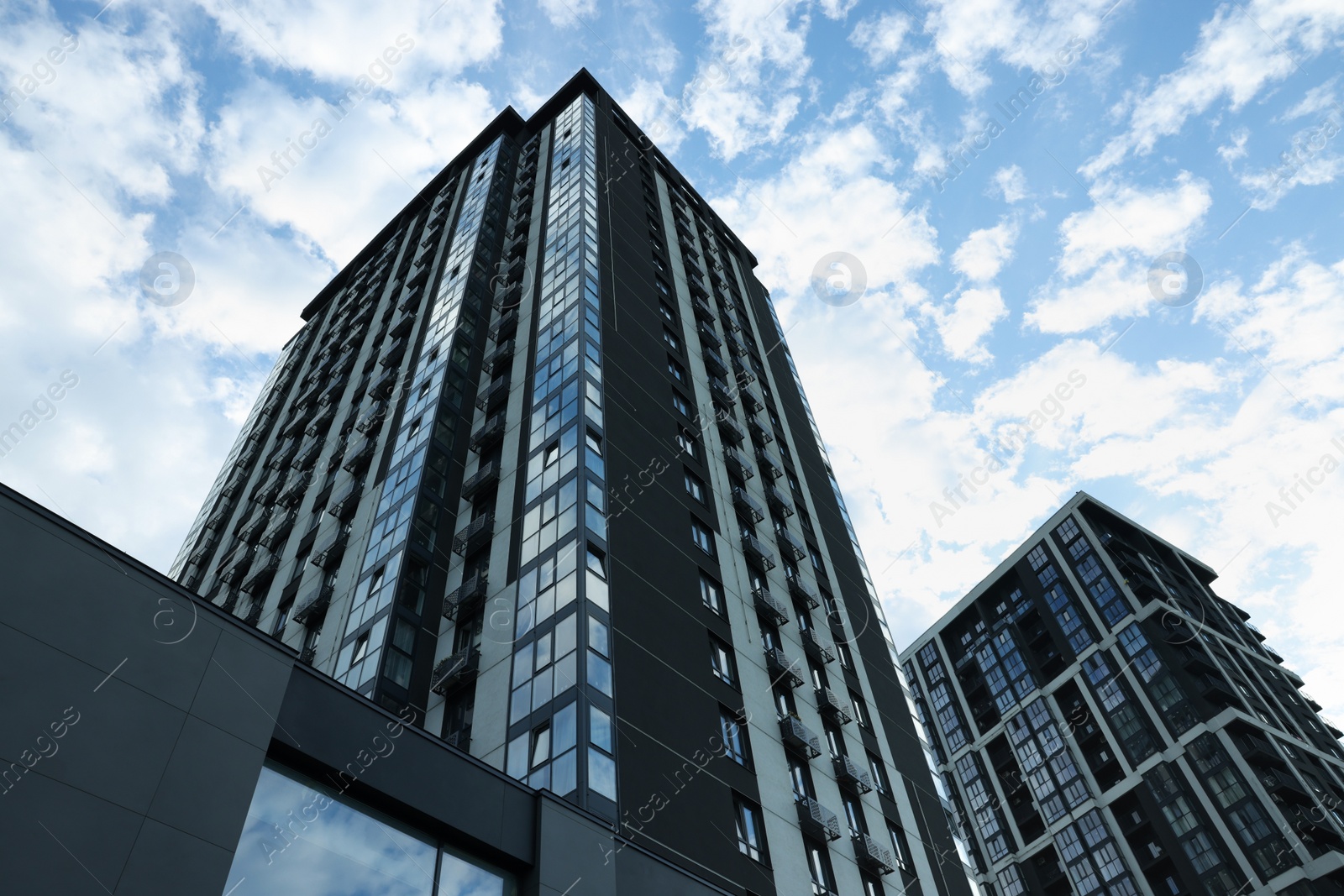 Photo of Modern skyscrapers against cloudy sky, low angle view