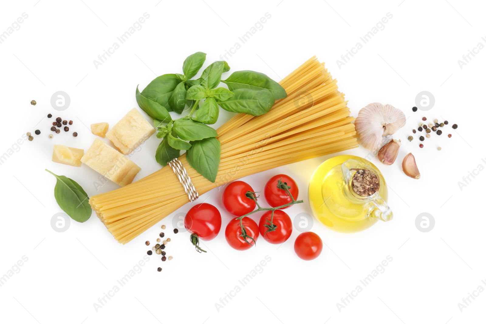 Photo of Uncooked spaghetti and ingredients on white background, top view