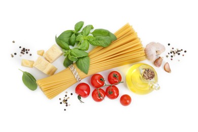 Uncooked spaghetti and ingredients on white background, top view