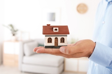 Photo of Real estate agent holding house model on blurred background