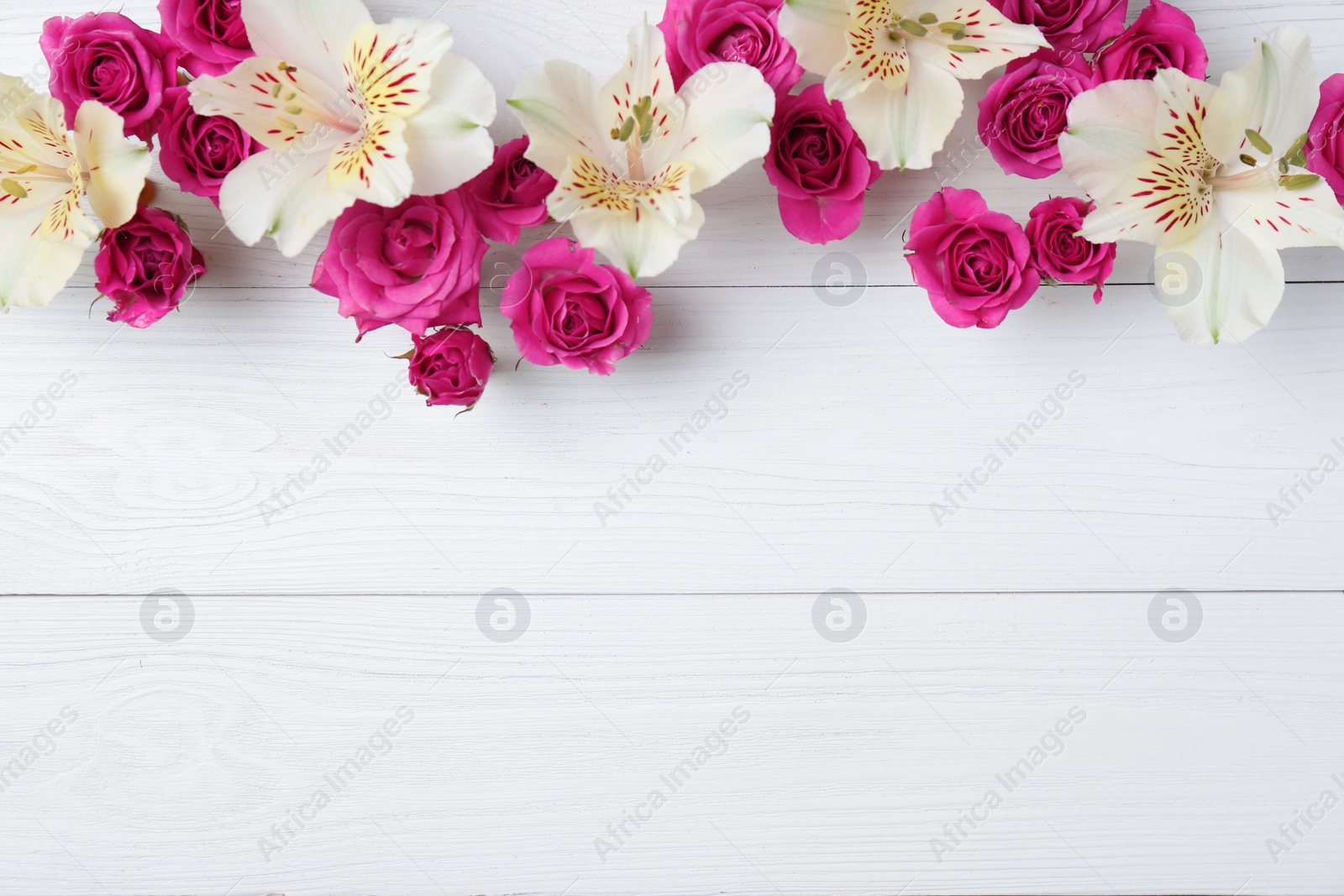 Photo of Fresh flowers on wooden background, top view with space for text