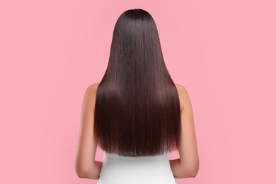 Photo of Woman with healthy hair after treatment on pink background, back view