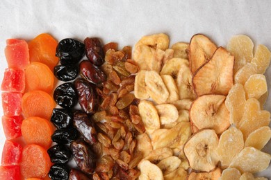 Different tasty dried fruits on paper, flat lay