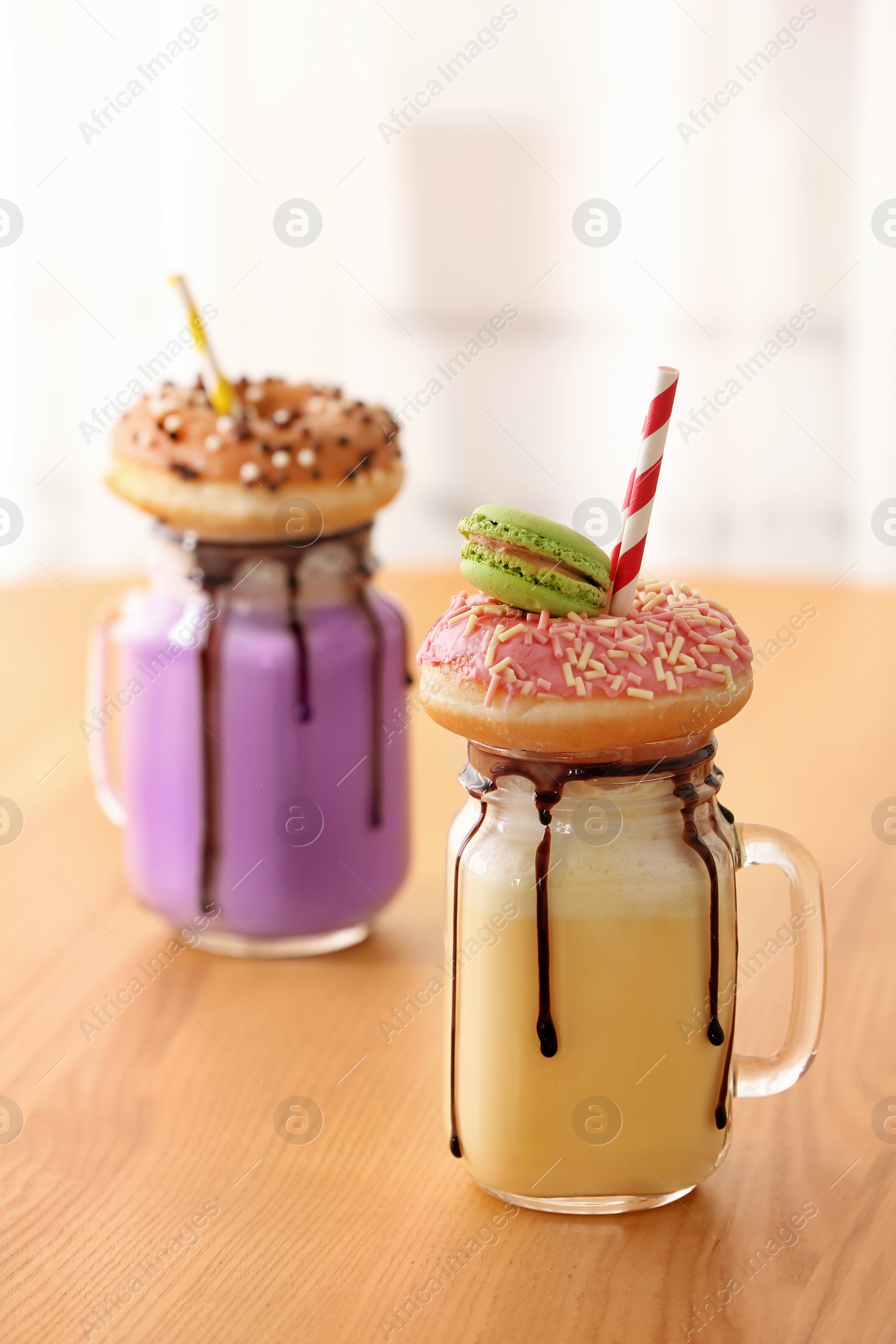 Photo of Mason jars with delicious milk shakes on table