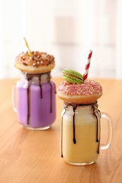 Mason jars with delicious milk shakes on table