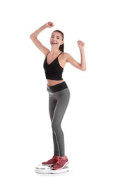 Happy young woman measuring her weight using scales on white background. Weight loss motivation