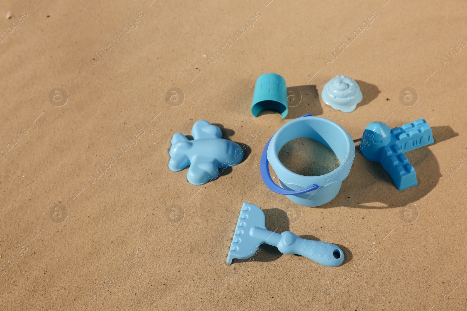 Photo of Set of plastic beach toys on sand, space for text. Outdoor play