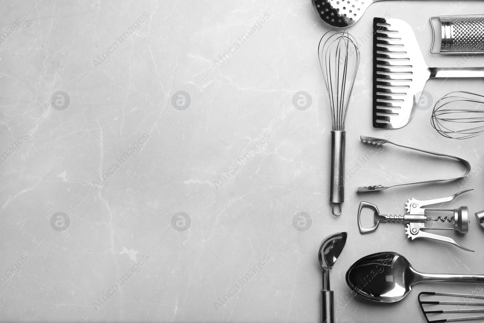 Photo of Different kitchen utensils on grey background, top view with space for text