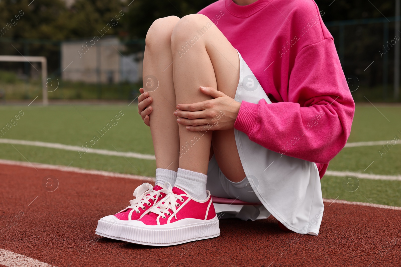 Photo of Woman wearing classic old school sneakers on sport court outdoors, closeup