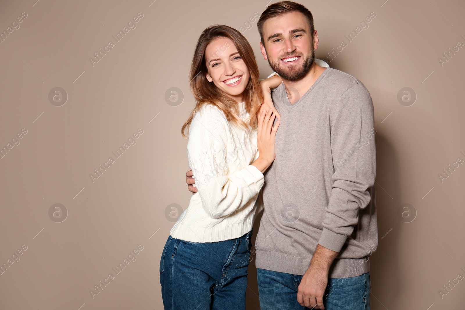 Image of Lovely couple in warm sweaters on beige background 