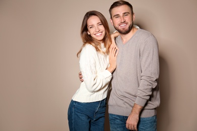 Image of Lovely couple in warm sweaters on beige background 