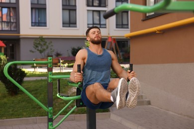 Photo of Man doing leg rise exercise at outdoor gym