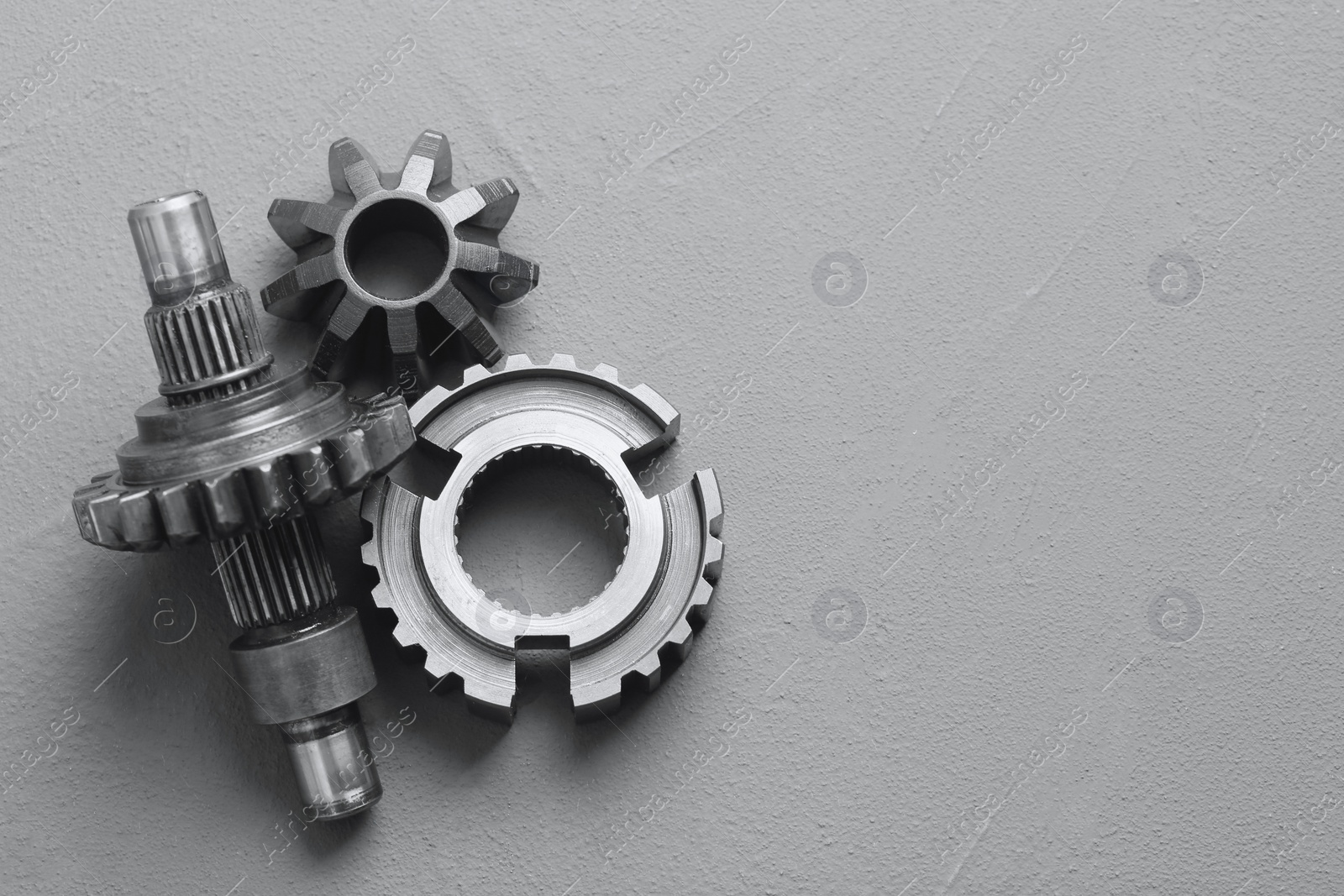 Photo of Different stainless steel gears on grey background, flat lay. Space for text