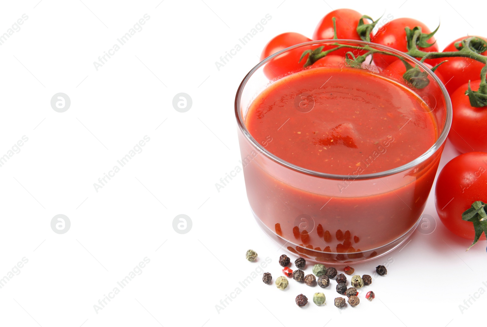 Photo of Glass of sauce, tomatoes and pepper isolated on white