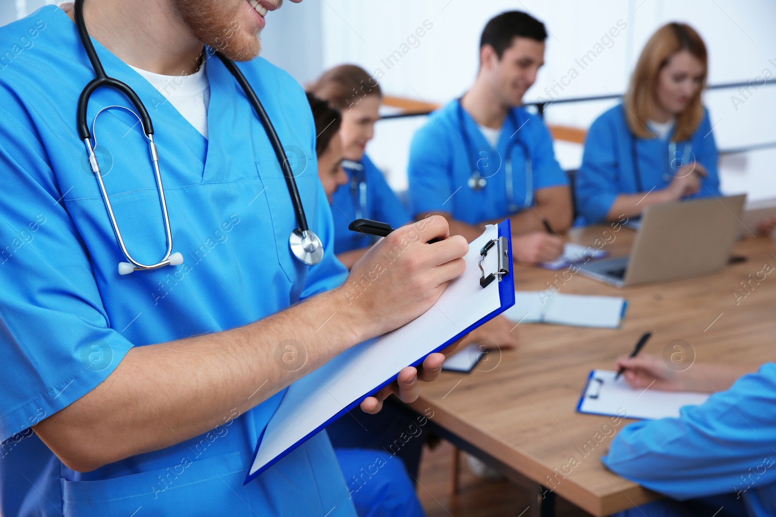 Photo of Medical student with groupmates in university library, closeup