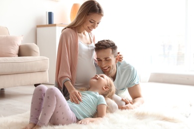 Photo of Young pregnant woman with her family at home