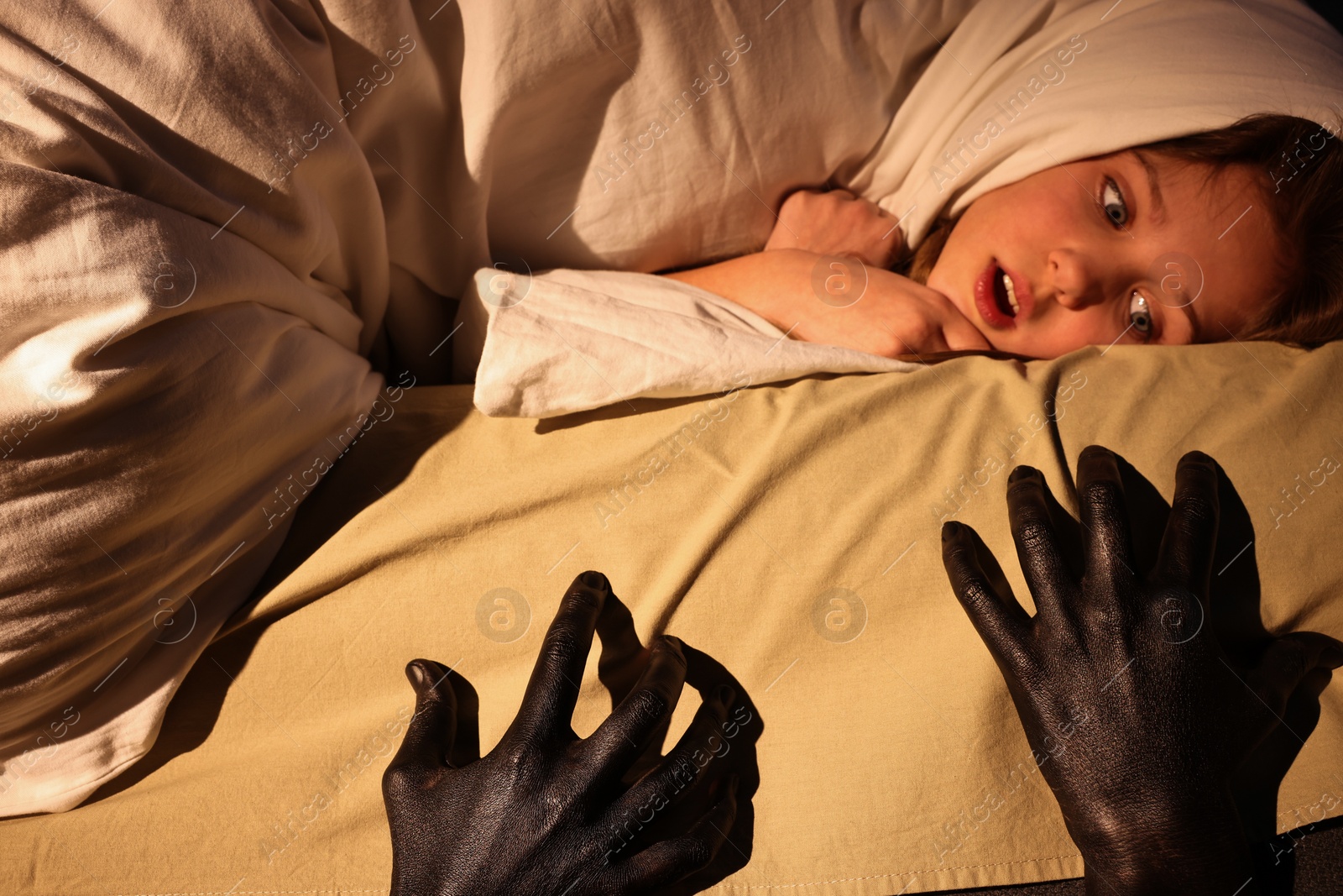 Photo of Childhood phobia. Scared girl and monster under bed at home, closeup