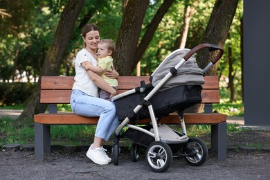 Photo of Happy nanny with cute little boy on bench in park