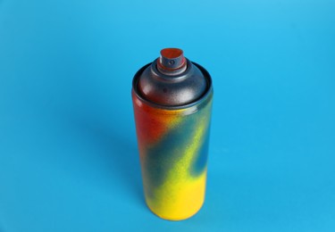 Photo of Used can of spray paint on light blue background